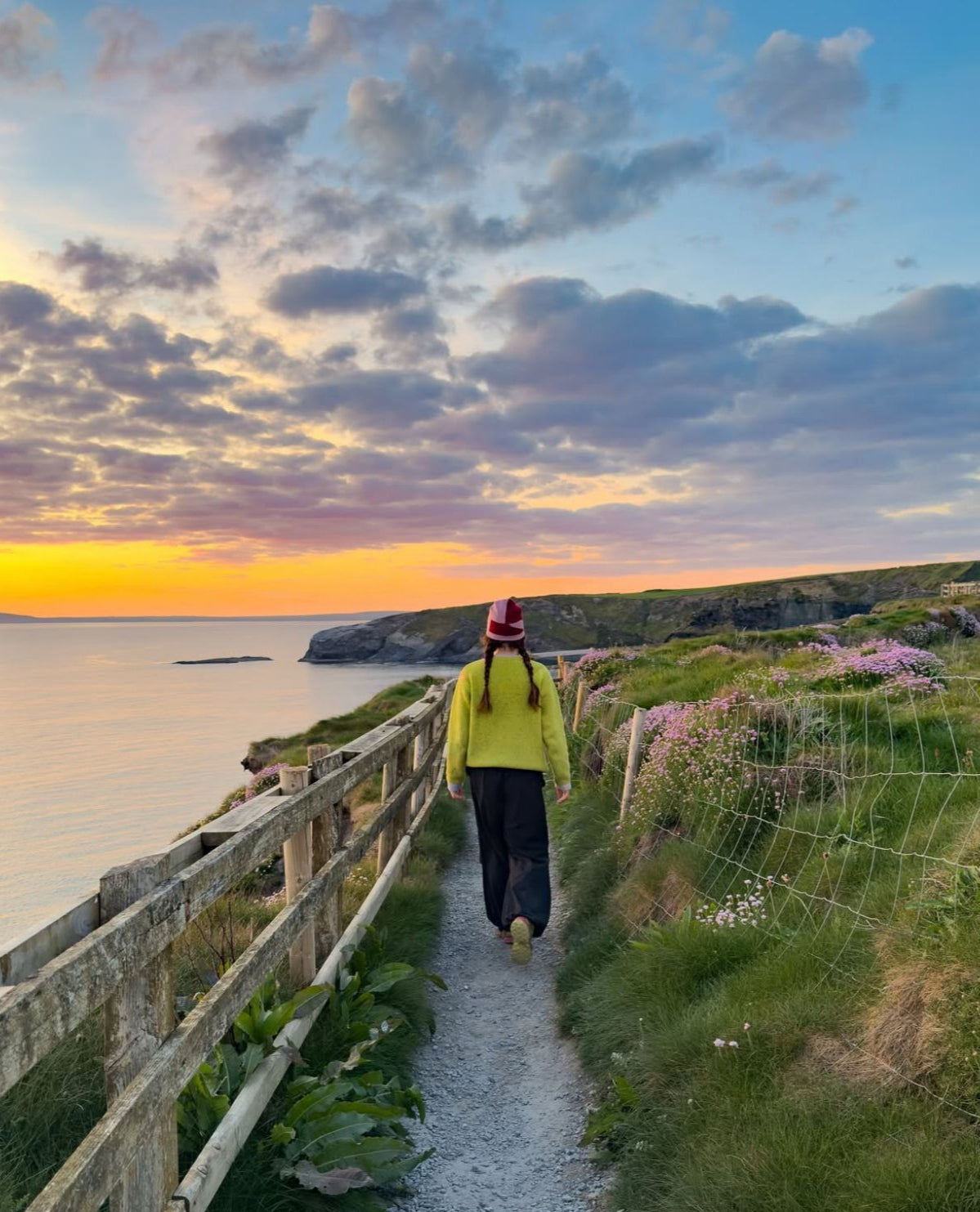 Roz Purcell wears her Wild Meadows Green Aoife Mc Namara Jumper walking through County Clare at sunset 