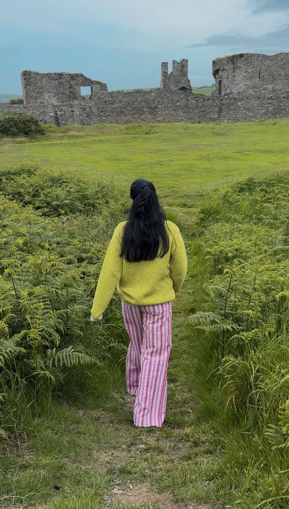 Tar Mar wearing her Wild Meadows Green AMN Jumper walking through a field in Ireland 